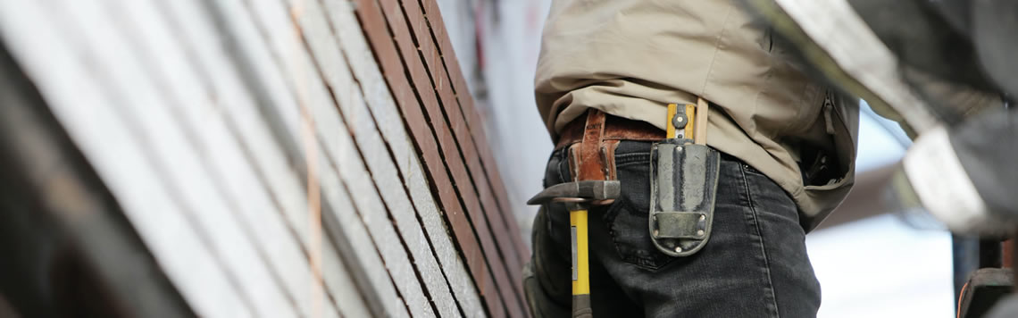 A photo of a handyman and his toolbelt working on a home.